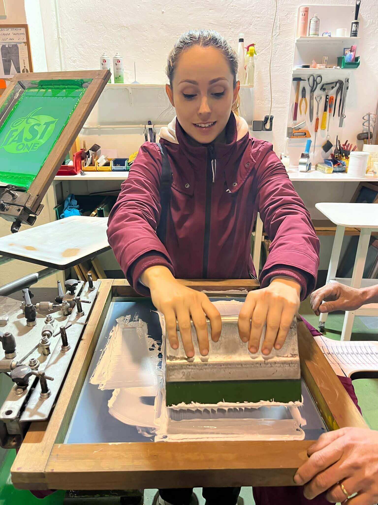 Una trabajadora del taller estampa una prenda con el pulpo de serigrafía